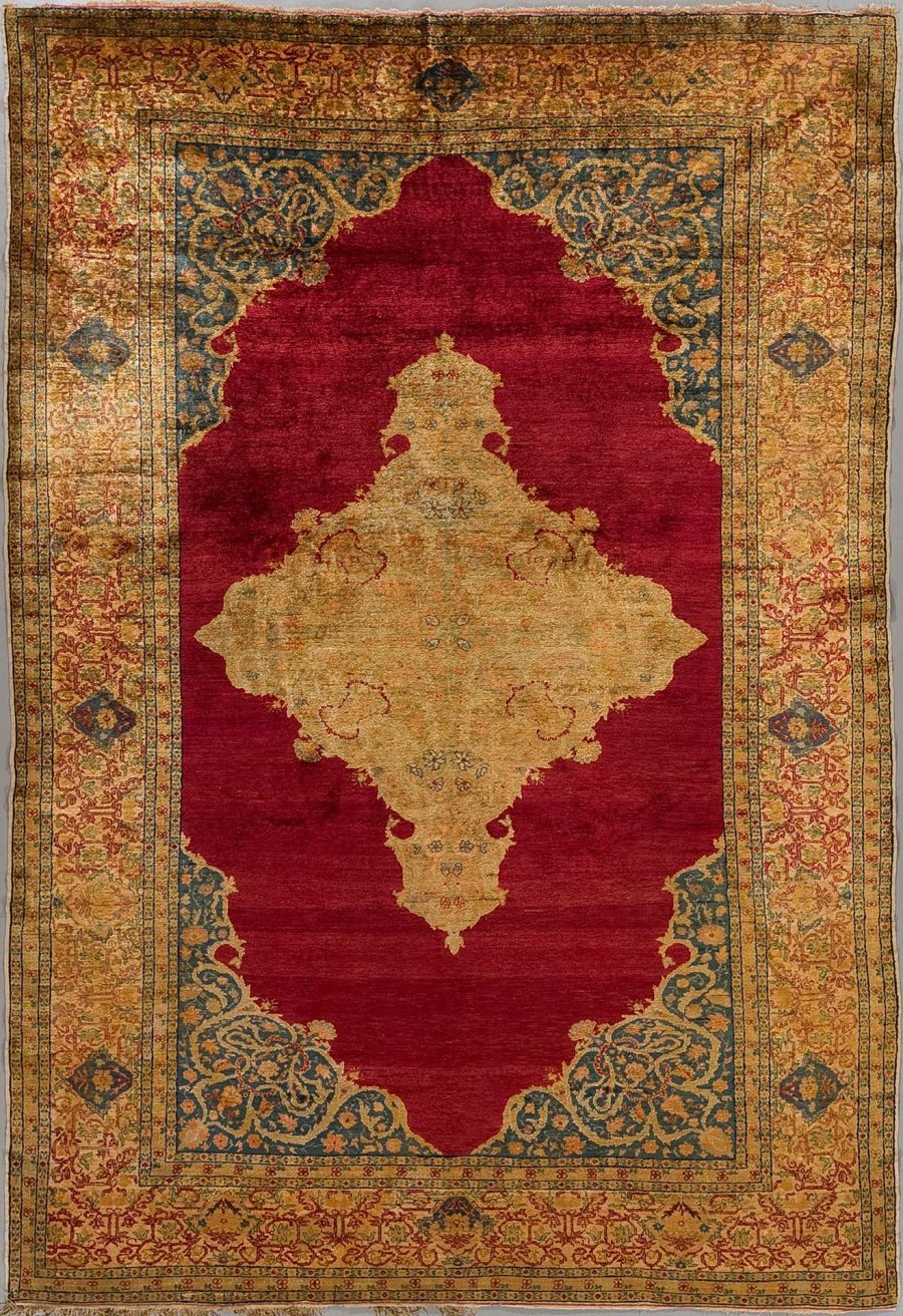 Antiker orientalischer Teppich mit zentraler roter Fläche und komplexen gold-blauen Mustern am Rand und in der Mitte.