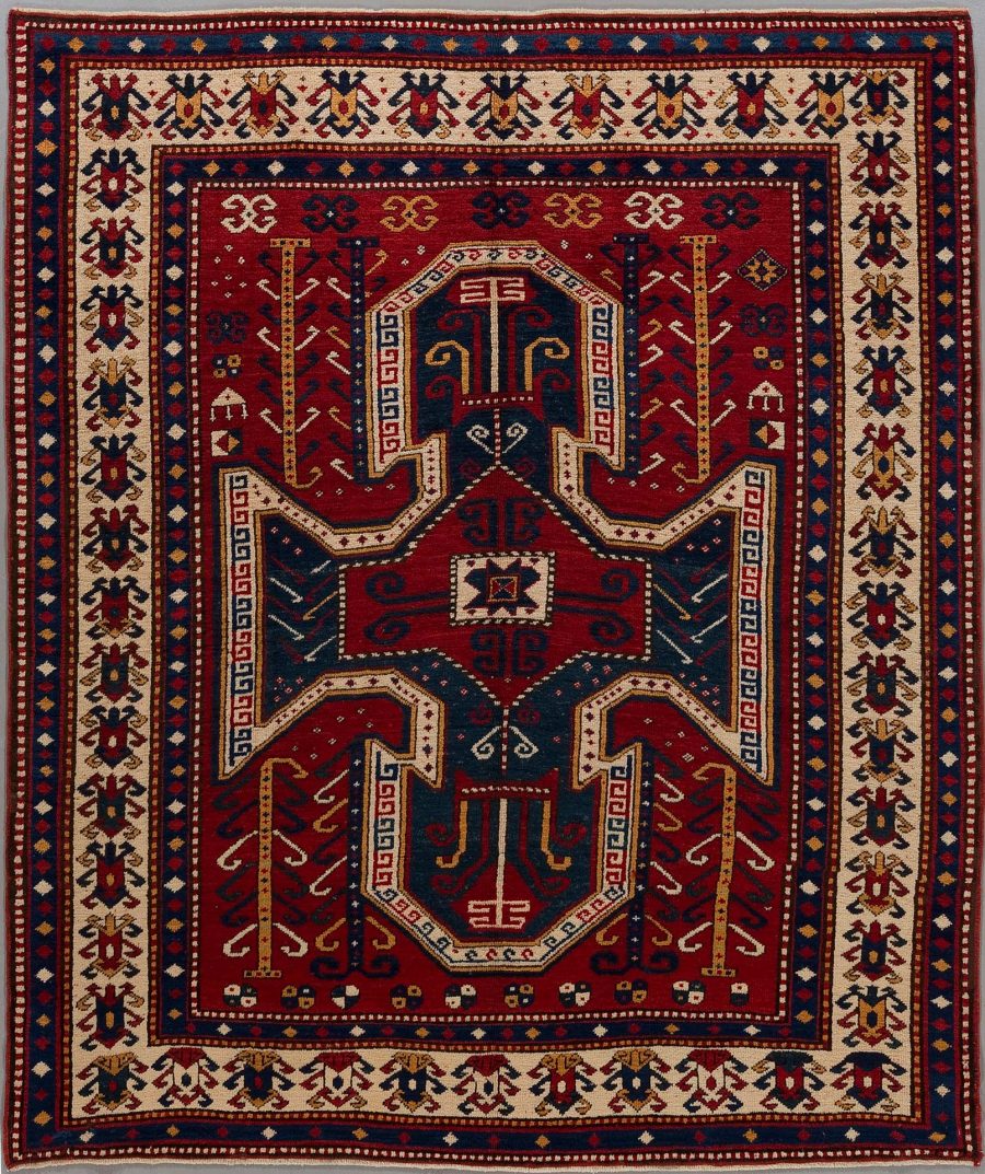 Traditioneller handgeknüpfter Teppich mit komplexen Mustern in Rot, Blau, Beige und Schwarz, umfasst von mehreren dekorativen Bordüren.