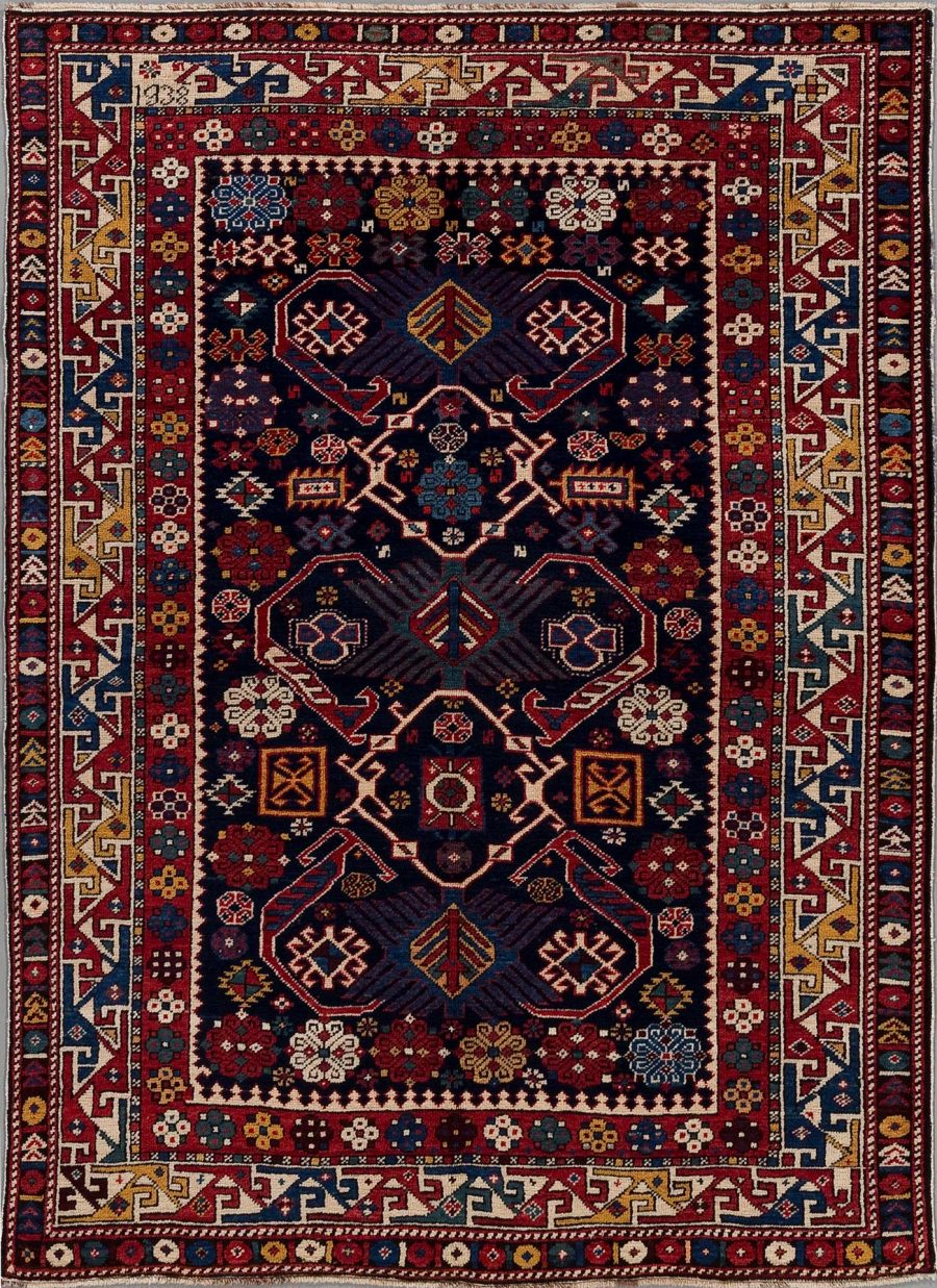 Detailreicher, handgeknüpfter Teppich mit traditionellen Mustern in Dunkelblau, Rot und Cremeweiß, verziert mit geometrischen und pflanzlichen Motiven, umgeben von mehreren verzierten Bordüren.