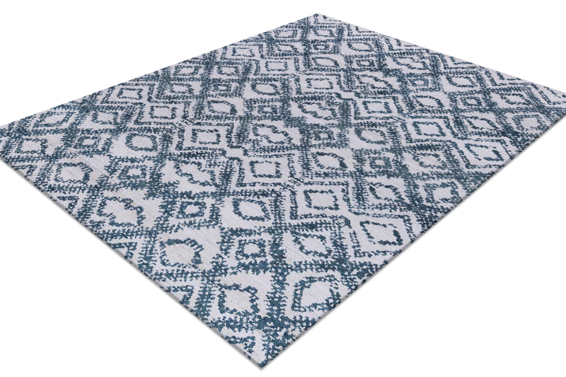 Ein moderner Teppich mit geometrischem Muster in Blau- und Grautönen auf weißem Hintergrund, flach ausgelegt auf einer ebenen Oberfläche.