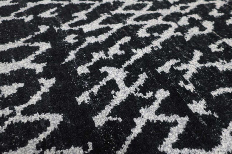 Nahaufnahme eines schwarz-weißen gemusterten Teppichs.