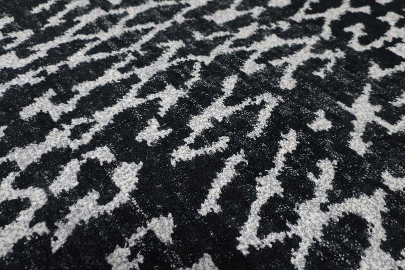 Nahaufnahme eines schwarz-weißen gemusterten Teppichs.