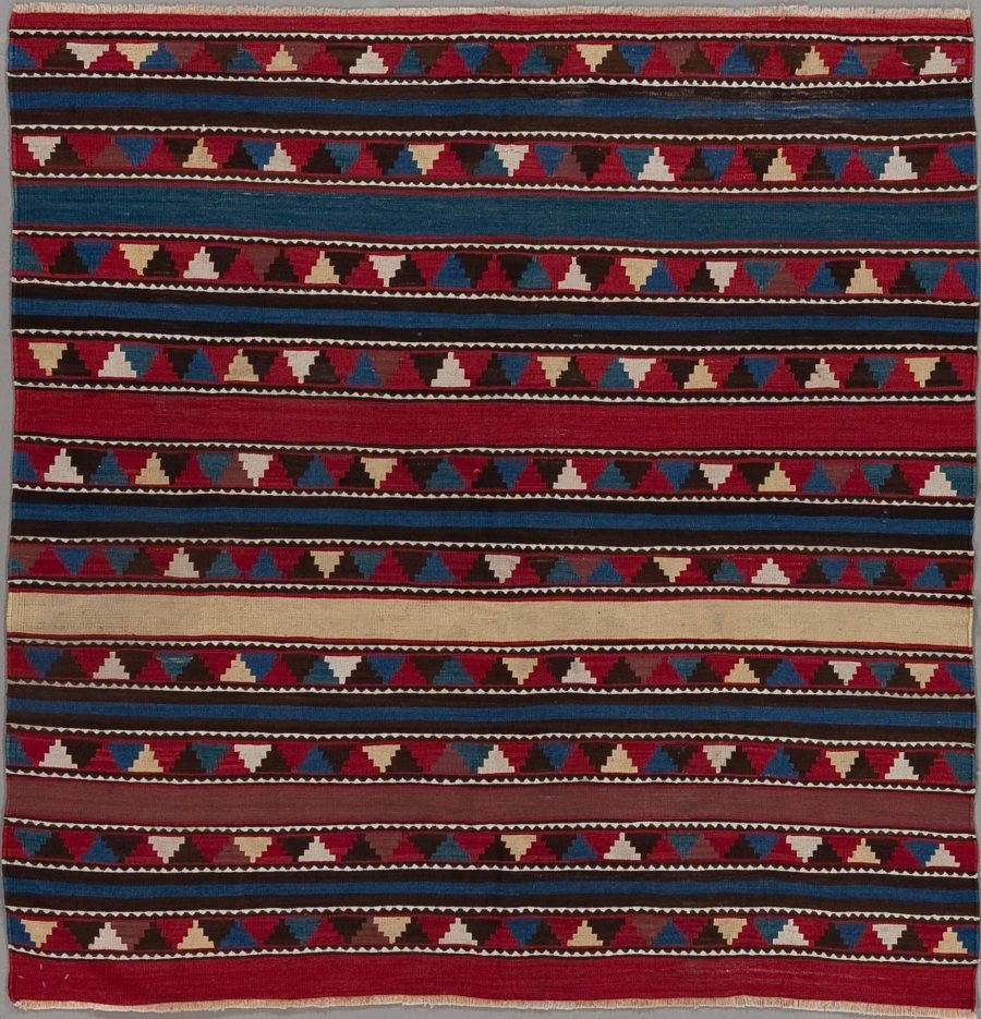 Traditioneller handgewebter Teppich mit horizontalen Streifen in Rot, Blau, Beige und Weiß, verziert mit wiederholten geometrischen Mustern.