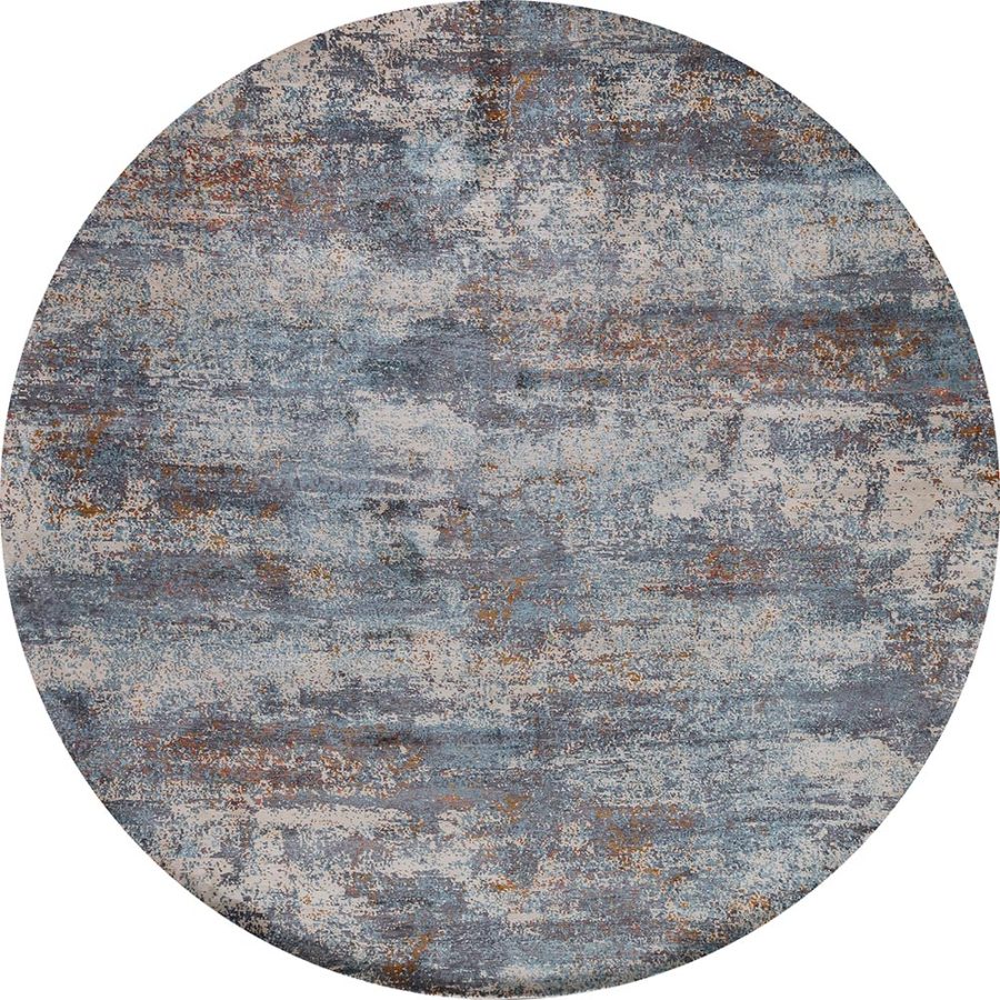 Runder Teppich mit abstraktem, verwaschenem Design in Blautönen und Rostorange-Akzenten.