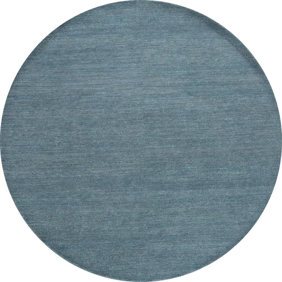 Runder Teppich in melierter blauer Textur.