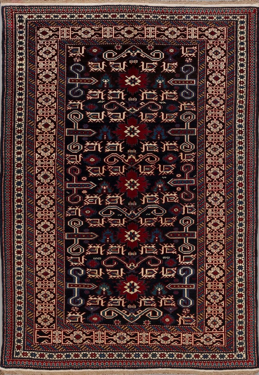 Traditioneller handgeknüpfter Teppich mit komplexem Muster aus roten, blauen, weißen und beigen Elementen, umgeben von mehreren dekorativen Bordüren.