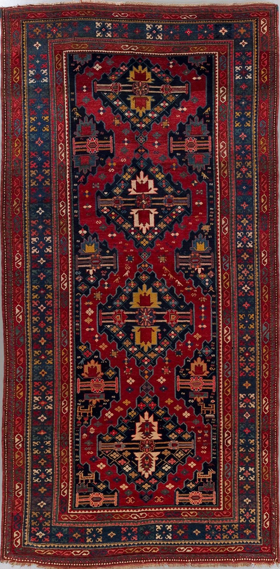 Antiker handgeknüpfter orientalischer Teppich mit komplexen geometrischen Mustern und Medaillon-Design in Rot-, Blau- und Goldtönen.
