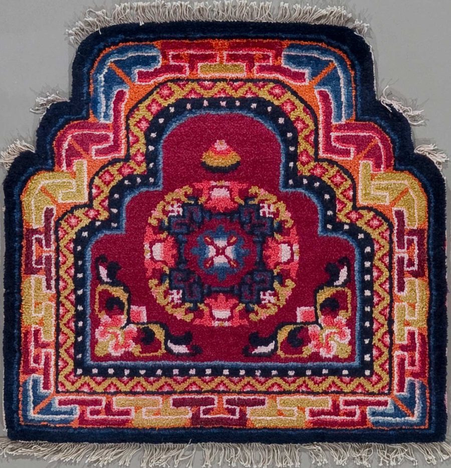 Handgeknüpfter Teppich mit traditionellem Muster in Rot, Blau, Gold und Weiß, Fransen an den kurzen Enden.