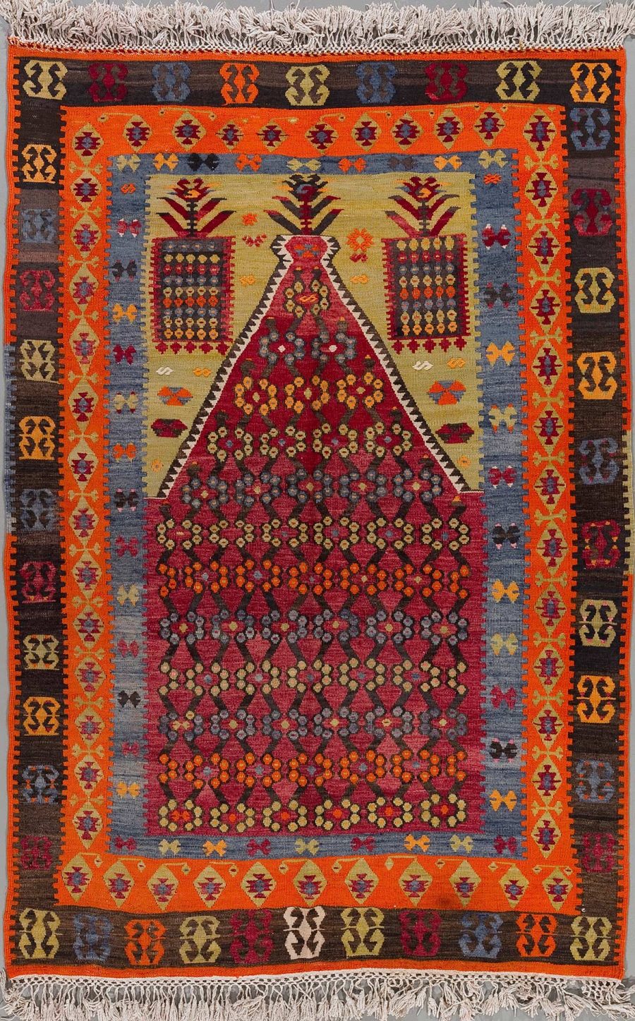 Handgeknüpfter Teppich mit reicher geometrischer Musterung und Blumenmotiven in lebendigen Farben von Rot, Blau, Orange und weiteren, abgerundet mit Fransen an den Enden.