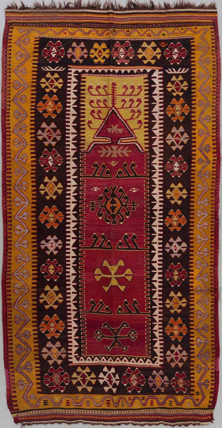 Traditioneller handgewebter Teppich mit geometrischen Mustern und Symbolen in Rot-, Braun-, Gelb- und Weißtönen, mit aufwändigen Bordüren und zentralem Medaillon-Design.