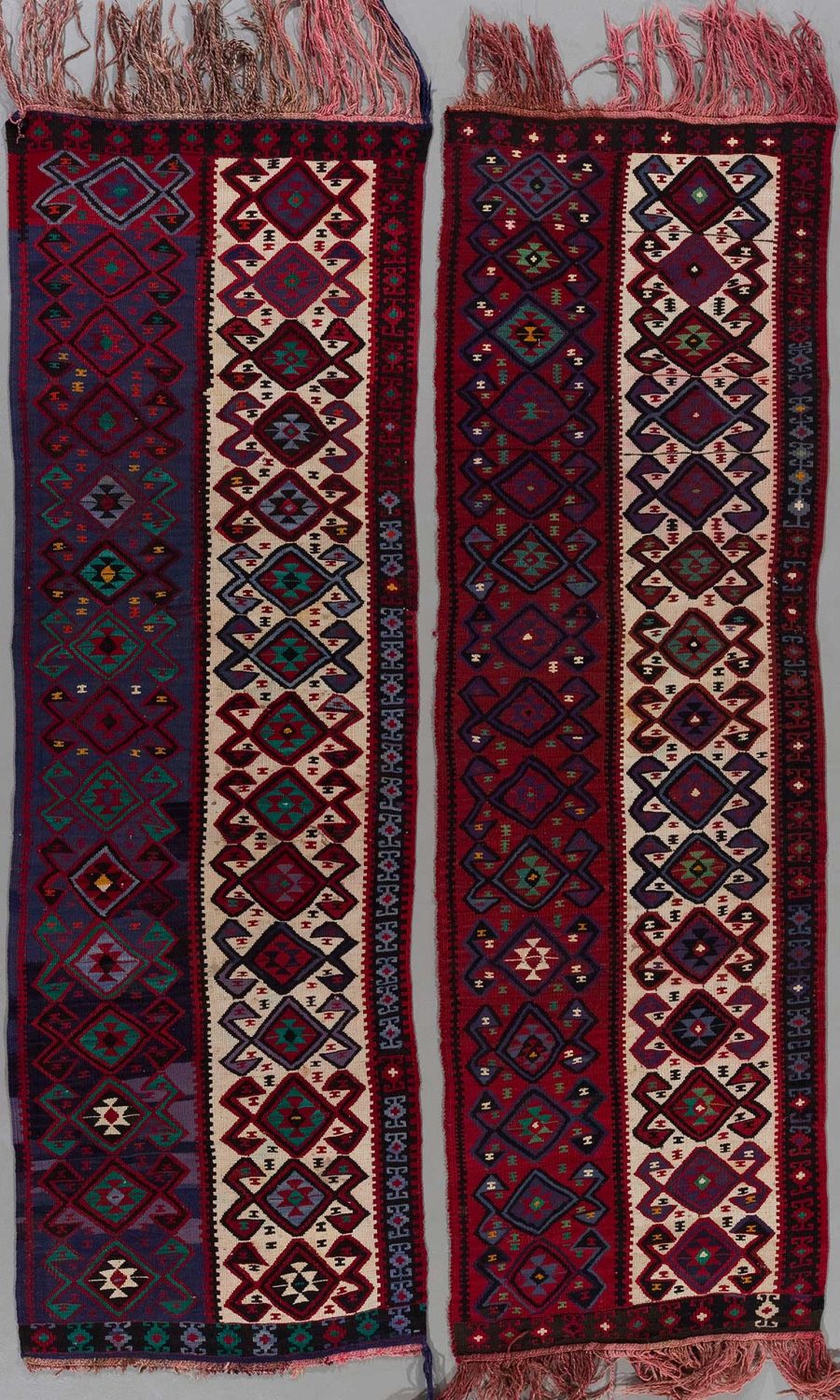 Zwei traditionelle Handgewebte Teppiche mit komplexen geometrischen Mustern in Rot-, Blau-, Schwarz- und Beigetönen, mit Fransen an den Enden.
