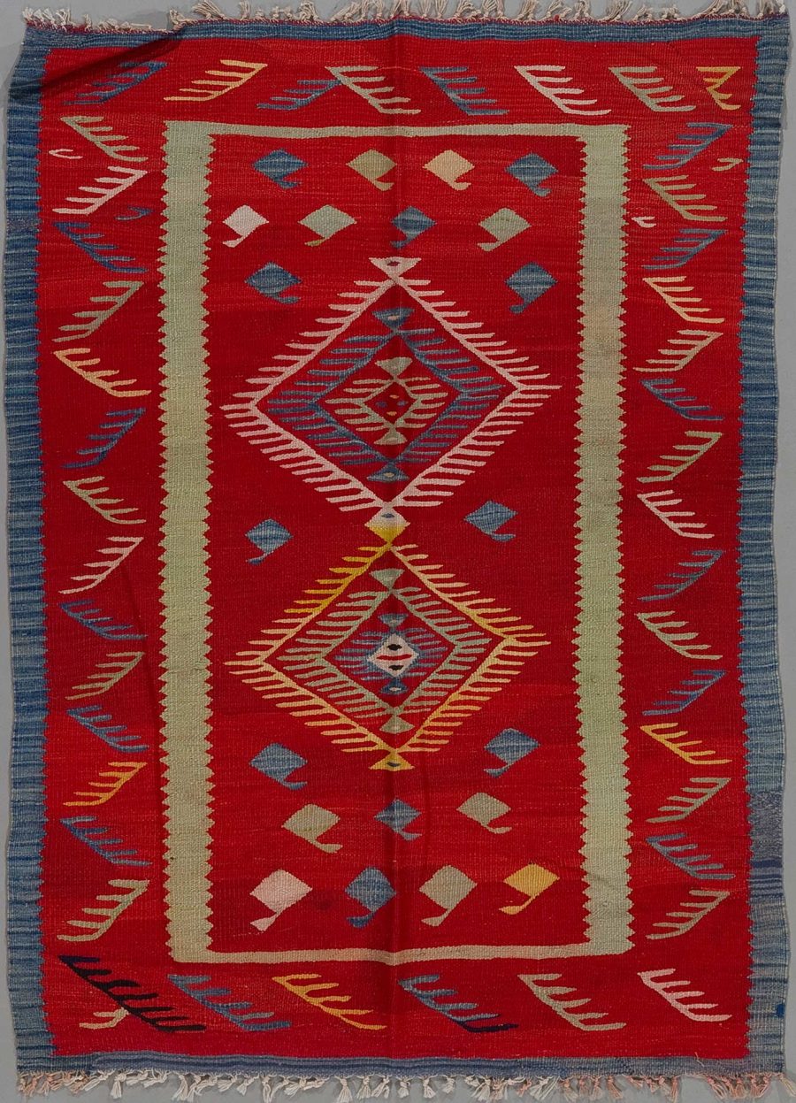 Handgewebter Teppich mit zentralem Diamantmuster und mehrfachen Bordüren in Rot, Beige, Blau und Gelbfarben. Das Design weist geometrische Formen und symmetrische Muster auf.