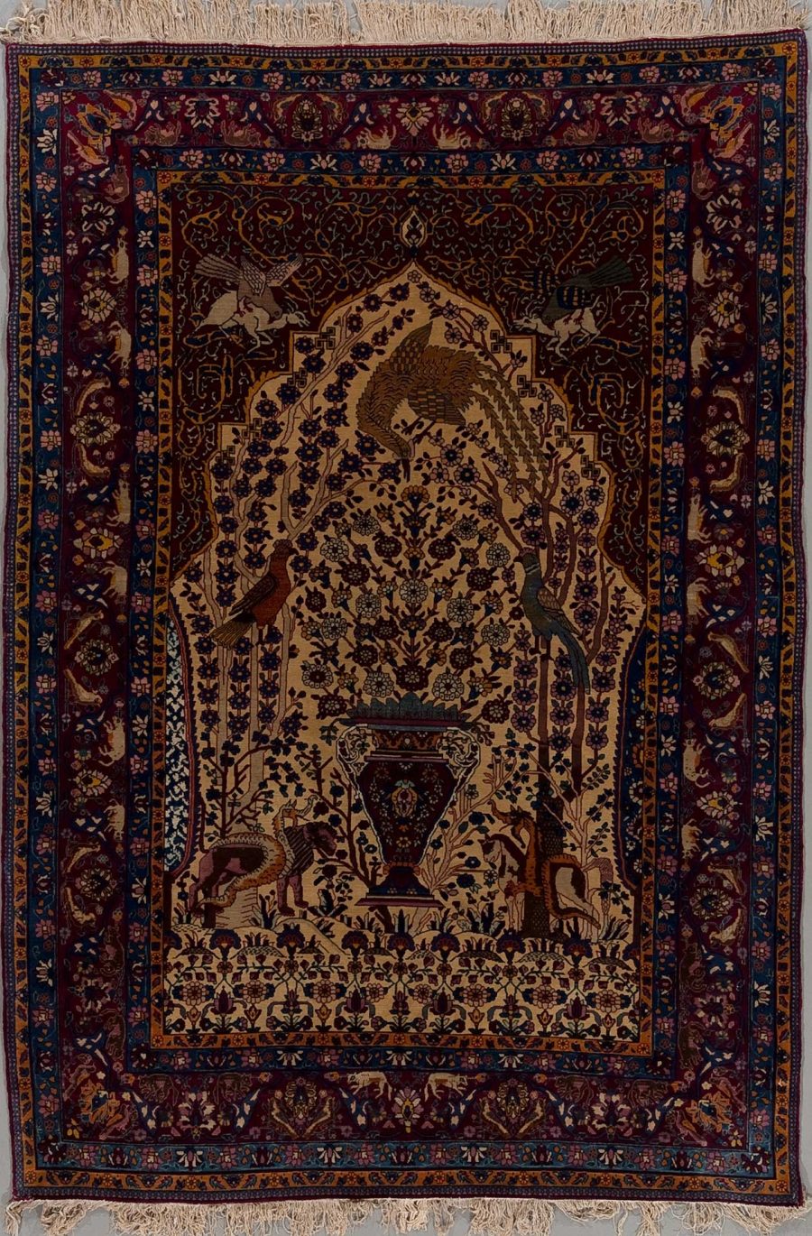 Traditioneller persischer Teppich mit aufwendigem Design, einschließlich floralem Muster und Tierdarstellungen, umgeben von einer dekorativen Bordüre.