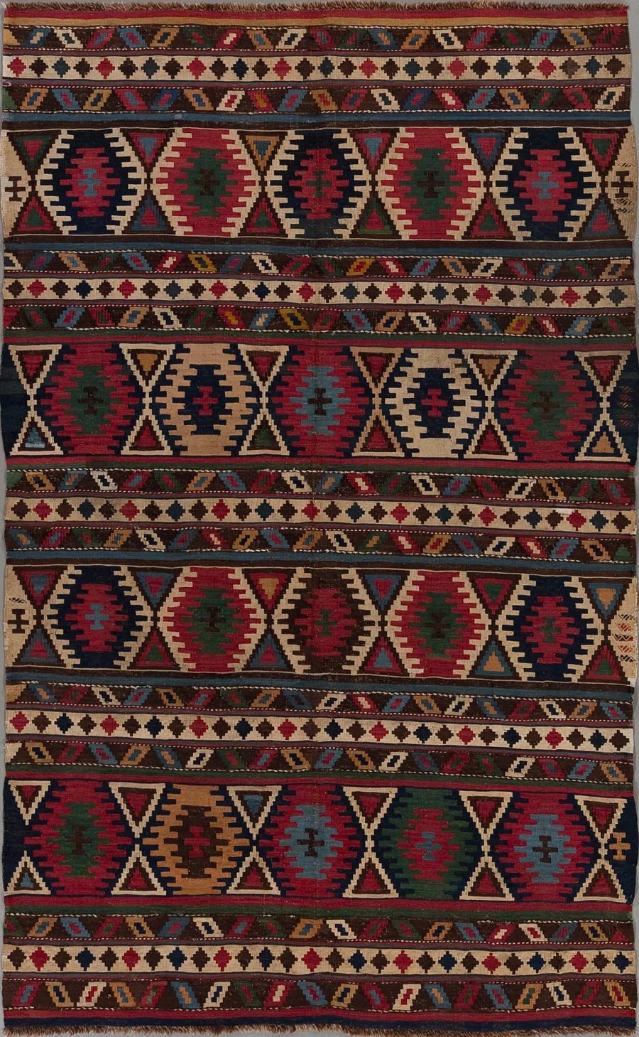 Traditioneller handgewebter Teppich mit wiederkehrenden geometrischen Mustern und mehrfarbigen Motiven auf dunklem Grund.