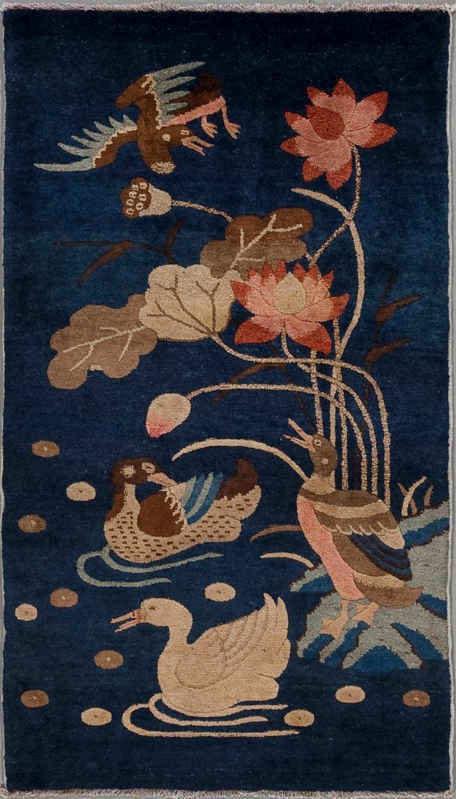 Handgeknüpfter Teppich mit einem detaillierten Motiv von Vögeln und Lotusblumen in mehreren Farben auf einem dunkelblauen Hintergrund.