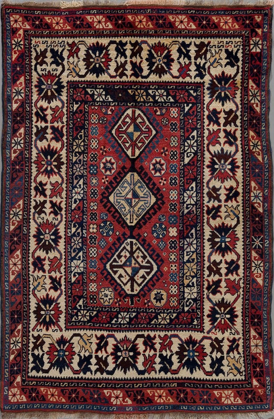 Detaillierter handgeknüpfter Teppich mit traditionellem persischem Muster in den Farben Rot, Blau, Schwarz und Beige mit zentralen geometrischen Motiven und einer umlaufenden Bordüre.