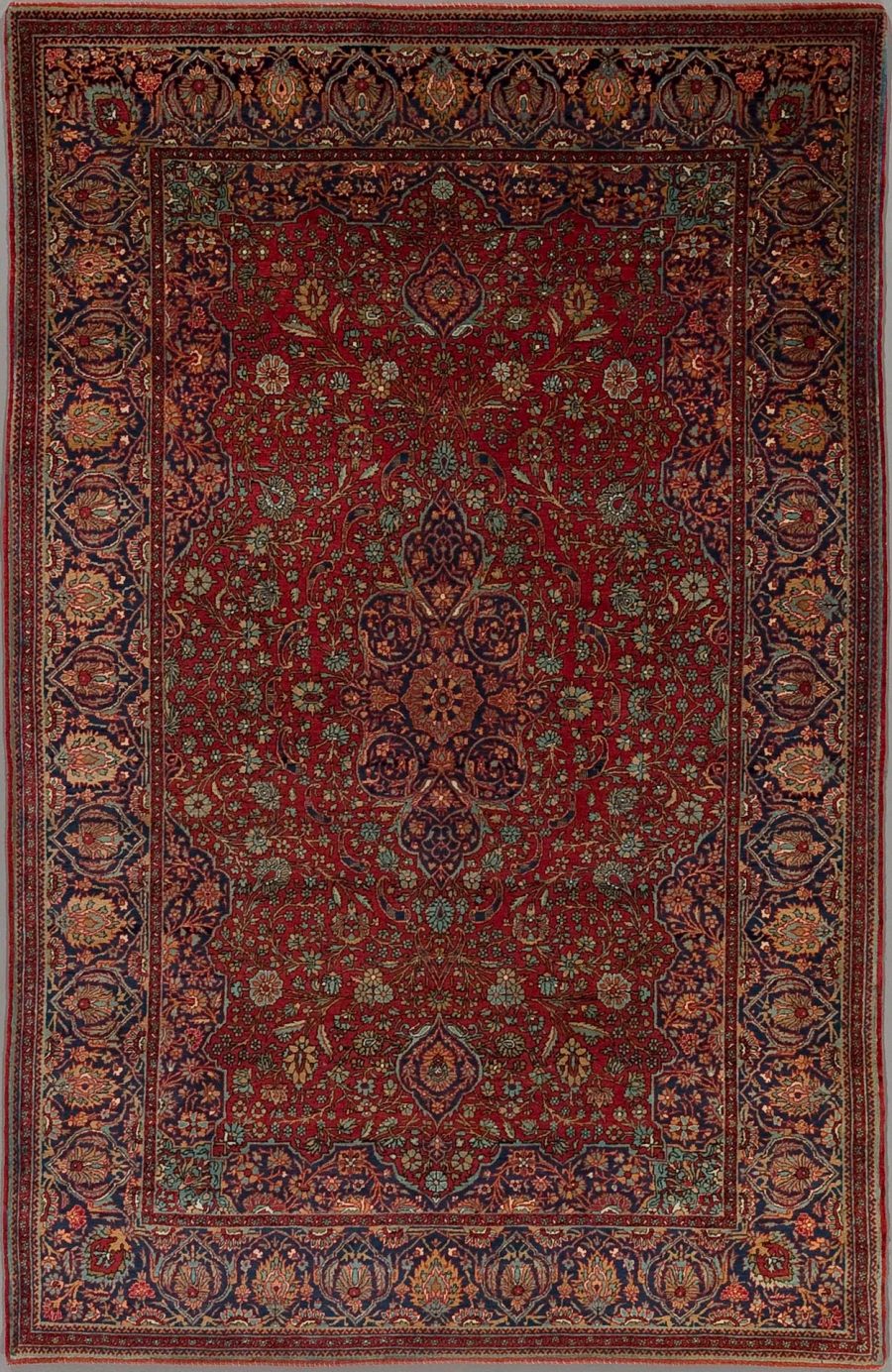 Detaillierter traditioneller persischer Teppich mit aufwendigem Muster in Rot-, Blau- und Beigetönen, zentralen Medaillons und Bordüren mit floralen und geometrischen Designs.