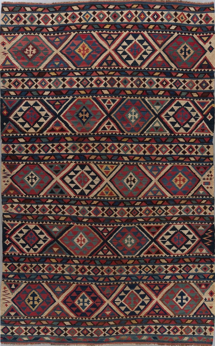 Traditioneller, handgewebter Teppich mit geometrischen Mustern und abstrakten Designs in einer Reihe von Farben, darunter Rot, Blau, Beige und Schwarz.
