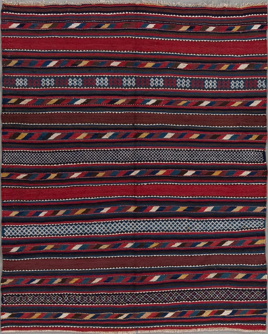 Textil mit traditionellen Mustern in verschieden breiten Streifen in Rot-, Blau-, und Brauntönen mit weißen und gelben Akzenten.
