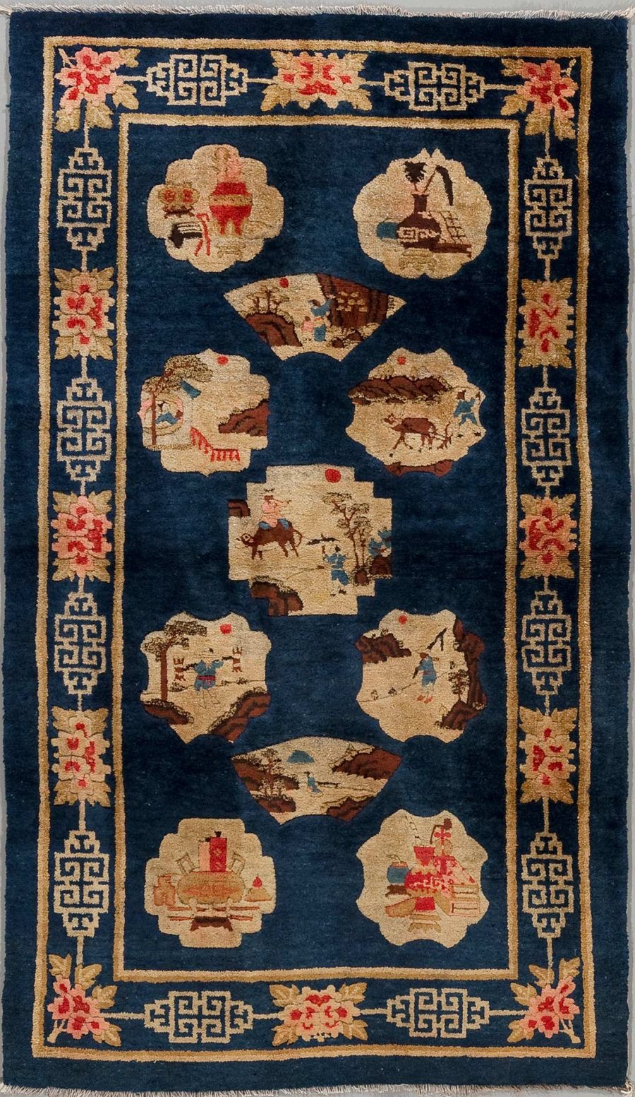 Antiker orientalischer Teppich mit tiefblauem Hintergrund und traditionellen Mustern, einschließlich mehrerer dekorativer Rahmen mit Blumen und geometrischen Designs sowie zentralen Illustrationen, die Szenen aus dem Alltagsleben zeigen, möglicherweise chinesischen Ursprungs.