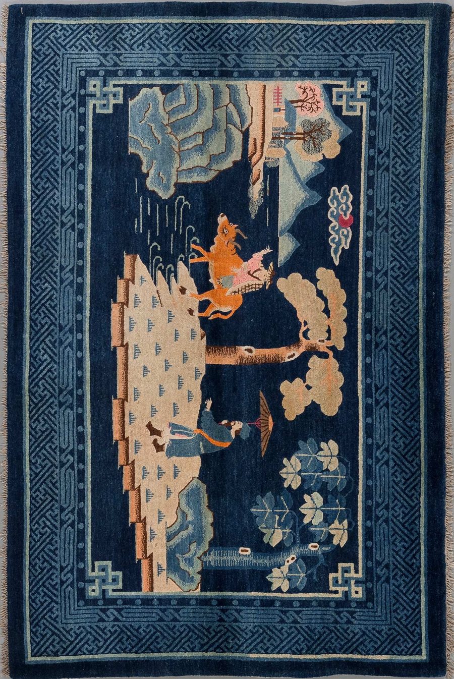 Antiker handgewebter Teppich mit asiatischen Motiven, darstellend einen Reiter auf einem Pferd und eine Person zu Fuß, umgeben von traditionellen Pflanzenmustern und geometrischen Grenzen.