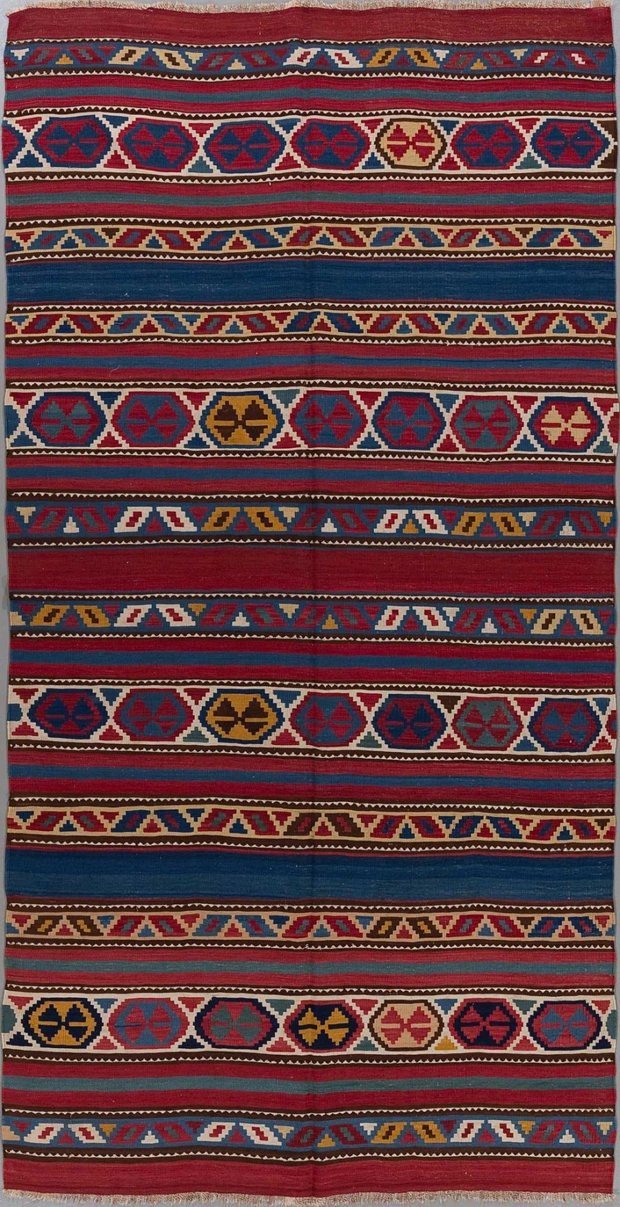 Traditioneller handgewebter Teppich mit vielfarbigen, horizontalen Streifen und geometrischen Mustern in Rot-, Blau-, Gelb-, Weiß- und Schwarztönen.