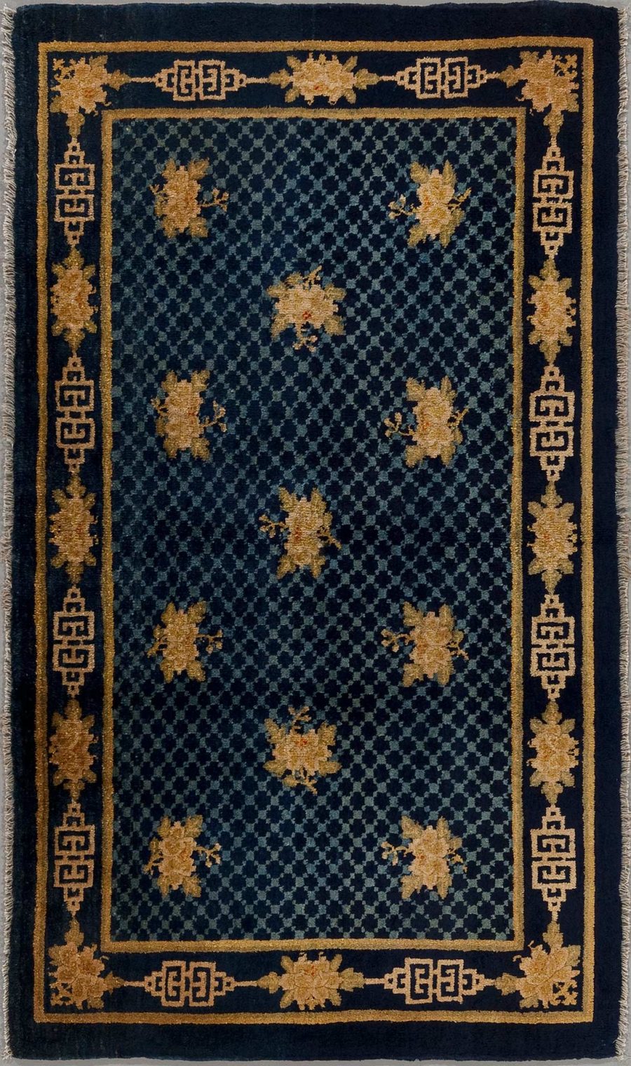 Traditioneller handgeknüpfter Teppich in Dunkelblau mit goldfarbenen Blumenmustern und geometrischem Randdesign auf schwarzem Hintergrund.