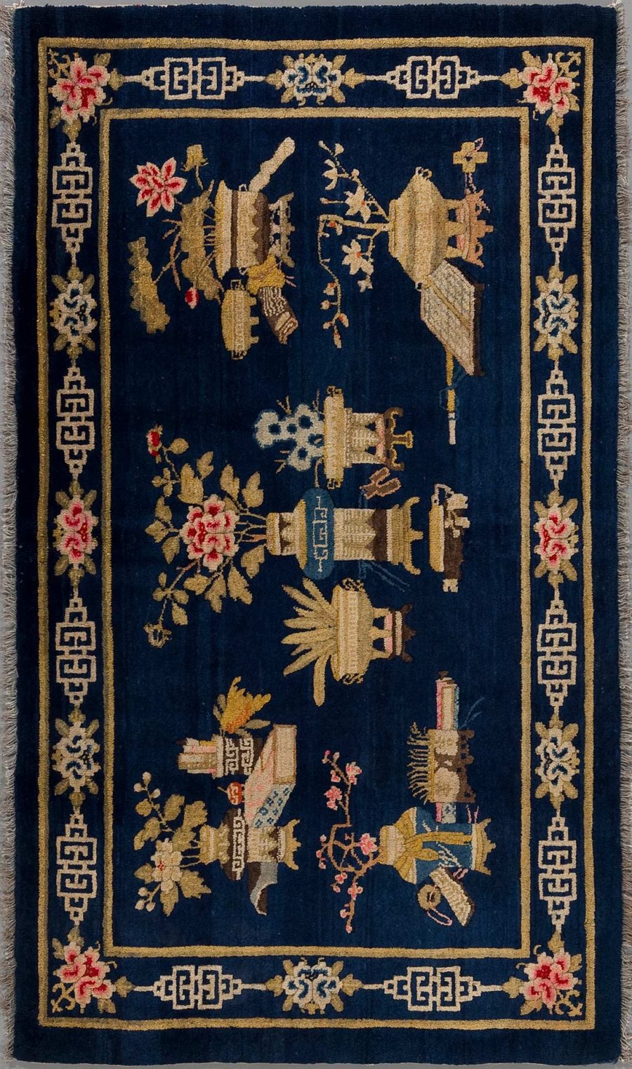 Antiker Teppich mit dunkelblauem Grund und detaillierter Stickerei in Gold und mehrfarbigen Akzenten, darstellend traditionelle asiatische Motive, darunter Vögel, Vasen und Blumen, umrandet von einem geometrischen Mäander-Muster.
