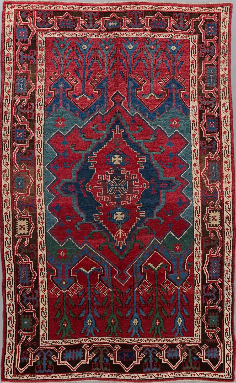 Traditioneller handgewebter Teppich mit komplexem Geometriemuster in den Farben Rot, Blau, Grün und Beige mit zentriertem Diamant-Design und mehrfachen, dekorativen Bordüren.