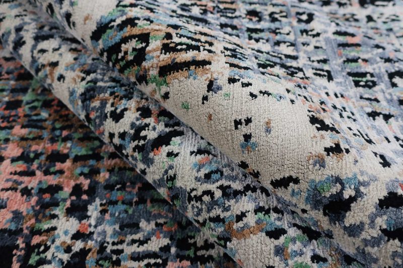 Nahaufnahme eines Teppichs mit vielfältigen Farben und organischen Motiven.