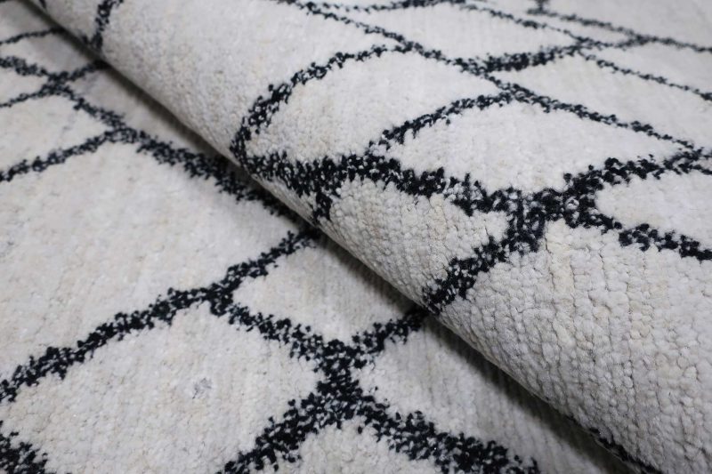 Weißer Teppich mit schwarzem Rautenmuster.