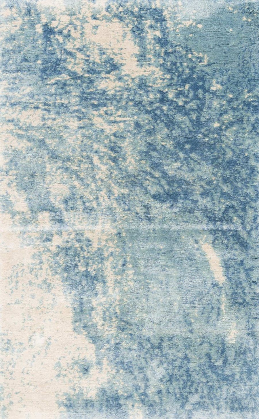 Nahaufnahme eines texturierten Teppichs mit blau-weißem Farbverlauf und Unschärfen, die ein abstraktes, wolkenartiges Muster erzeugen.