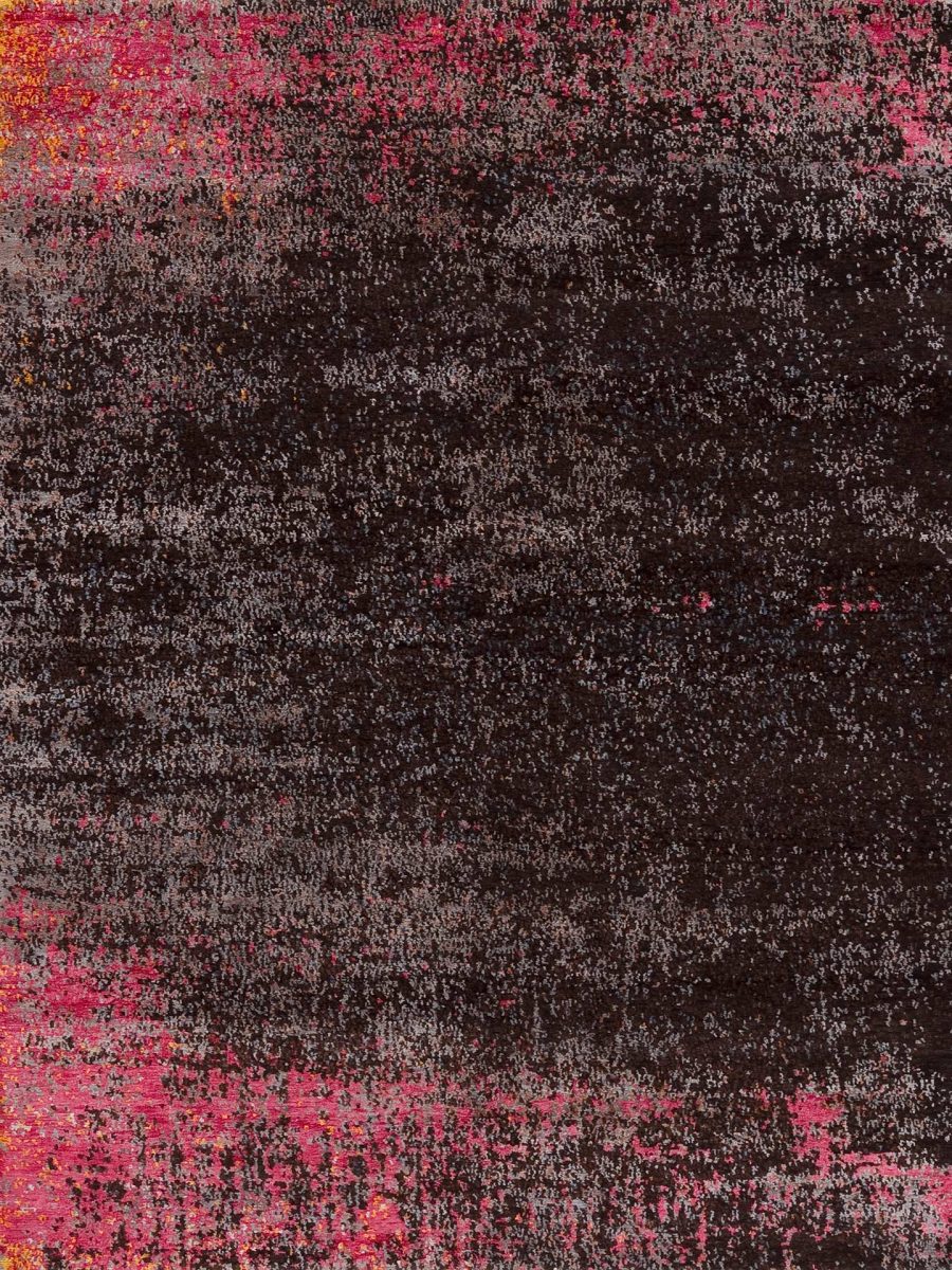 Abstrakter Teppich mit grober Textur und überwiegend dunklen Farbtönen, durchsetzt mit Flecken von Rosa und leuchtenden Rottönen am unteren Bildrand.
