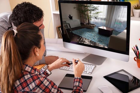 Zwei Personen betrachten einen Computerbildschirm mit einer Darstellung eines modernen Wohnzimmerinterieurs.
